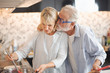 © linghaa - Closed up senior Caucasian couple are cooking and testing a meal or health food which smile and felling happy in kitchen at home. Old man kiss old woman. Senior family activity at home concept.