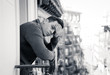 © SB Arts Media - Unhappy man suffering from depression feeling desperate, isolated and worthless on home balcony