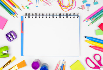 Wall Mural - Blank coil notebook with school supplies frame against a white background. Back to school concept. Copy space.