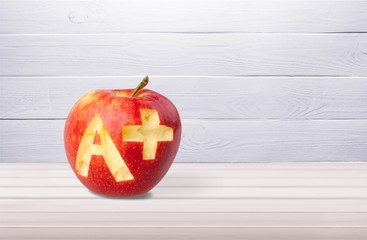 Wall Mural - Photo of red apple with A+ on the school desk