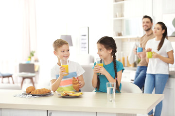 Canvas Print - Happy family having breakfast together in kitchen