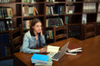 © Africa Studio - Pretty student with laptop studying in library