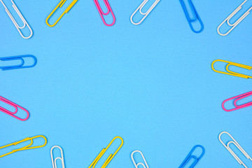 Wall Mural - Paper clip frame. Top view on a blue paper background with copy space.