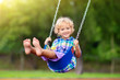 © famveldman - Child on playground. swing Kids play outdoor.