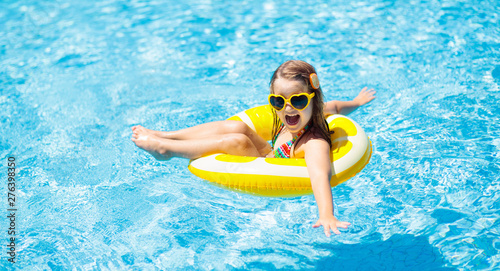 Cuadros en Lienzo Child in swimming pool on ring toy. Kids swim.