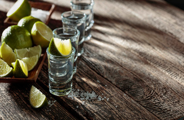 Tequila with  salt and lime on a old wooden background.