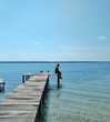 © ByronObed - Man sitting on a pier watching the sunset