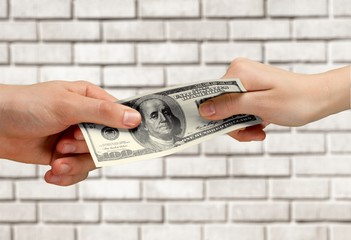 Wall Mural - Two hands holding one hundred dollars banknote over blue background