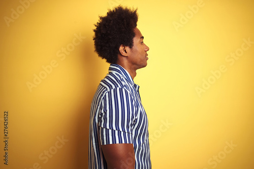 American Man With Afro Hair Wearing Striped Shirt Standing Over