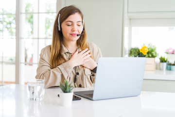 Canvas Print - Beautiful young operator woman working with laptop and wearing headseat smiling with hands on chest with closed eyes and grateful gesture on face. Health concept.