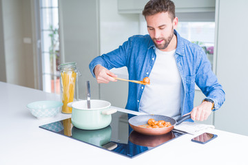 Handsome man cooking pasta at home