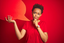 Young African American Woman Holding Speech Bubble Over Red Isolated Background Serious Face Thinking About Question, Very Confused Idea