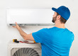 © stockphoto-graf - Installation service fix  repair maintenance of an air conditioner indoor unit, by cryogenist technican worker in blue shirt baseball cap