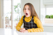 © Krakenimages.com - Young beautiful blonde kid girl wearing casual yellow sweater at home afraid and shocked with surprise and amazed expression, fear and excited face.