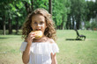 © bisonov - cute little girl eating a hamburger or cheeseburger