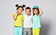 © FAB.1 - full body shot of three children in bright clothes, two girls and one boy. Triplets, brother and sisters.