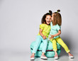 © FAB.1 - Two friends of twins - two girls in bright clothes have fun at the birthday party fun room decoration candy macarons