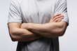 cropped view of man standing with crossed arms isolated on grey, human emotion and expression concept