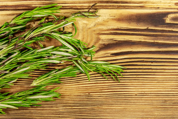 Fresh rosemary herbs on a wooden table. Top view