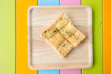 Fresh baked sliced garlic bread on a rustic wooden cutting board