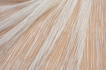 Synthetic fabric. Pleated organza. White colour. Texture, background, pattern.