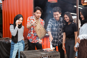 Group of friends grill food with a skewer in the building rooftop