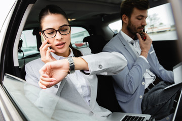 Wall Mural - Young business people working together while traveling by a car.