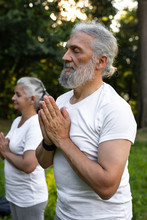 Senior Couple Is Practicing Meditation In The Park