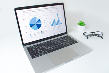 Poster - Modern white table with laptop computer with financial statistics report