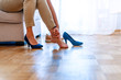 © Dragana Gordic - Tired businesswoman with joint ache touching her ankle sitting on a couch at home. Woman massaging her legs after wearing high heels all day at work in office