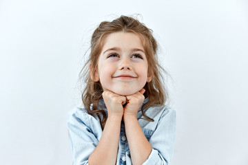 dreamy,pleased, thinking emotion . wish concept. little child girl face portrait on white backgound.