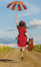 Photo Of Beautiful Young Woman With Suitcase On The Road Near Field Background