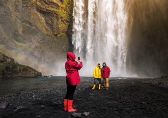 friends are photographed before a waterfall in Iceland