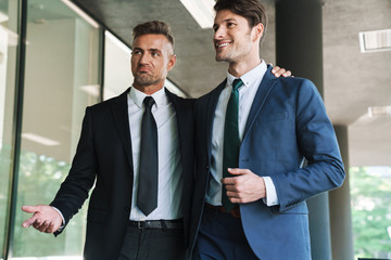 Sticker - Portrait of two joyful businessmen partners walking outside job center during working meeting