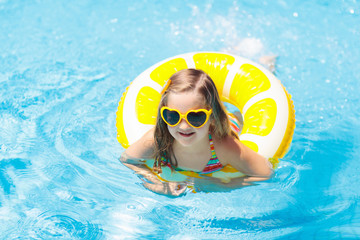 Wall Mural - Child in swimming pool on ring toy. Kids swim.