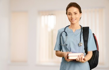 Canvas Print - Attractive young female doctor student on background