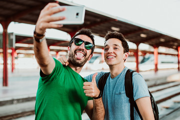 .two brothers on the platform waiting for the train to start their summer vacation. taking pictures 