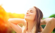 Young Relaxed Woman On Blurred Nature Background