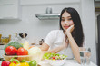 © Vittaya_25 - Dieting. beautiful young woman slim body in white shirt looking at camera with healthy food, fresh vegetable salad sitting in kitchen interior in house, lifestyle, good healthy and diet food concept