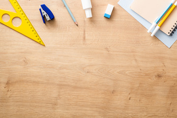 Modern school supplies on wooden desk table background. Back to school concept. Flat lay, top view.