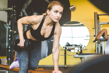 Canvas Print - Working out with dumbbell weights at the gym.Fitness Women exercising are lifting dumbbells. Fitness muscular body.Workout at gym.