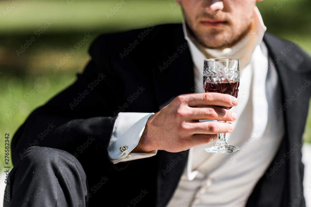 cropped view of victorian man holding wine glass with drink - obrazy, fototapety, plakaty 