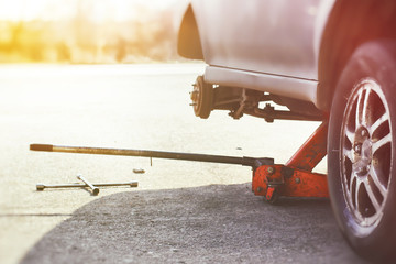 A floor jack and wheel wrench ready for wheel repair