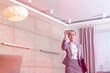 © MDBPIXS - Confident young female realtor photographing while standing in apartment