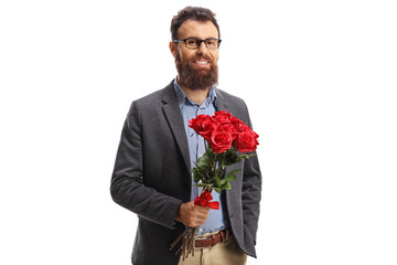 Wall Mural - Bearded young man in a holding a bunch of red roses and smiling