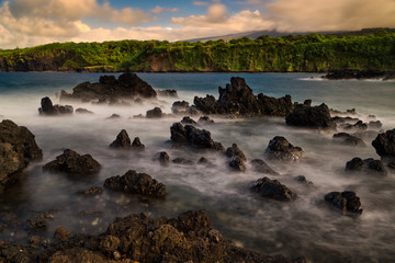 Rocky Maui shoreline with cliffs and sea stacks at sunset - Hawaii, USA