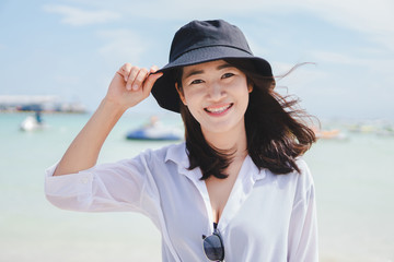 Wall Mural - Asian girl enjoying her vacation by the sea