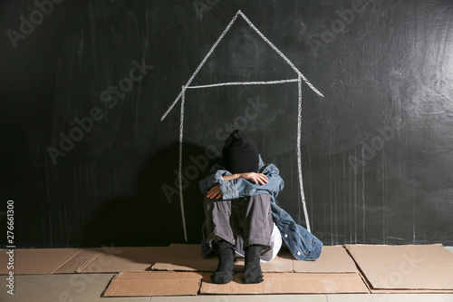 Cuadros en Lienzo Homeless little girl sitting on floor near dark wall