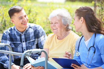 Wall Mural - Caregiver and grandson with senior woman in park