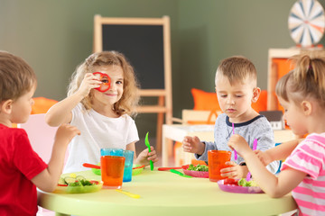 Sticker - Cute little children eating tasty lunch in kindergarten